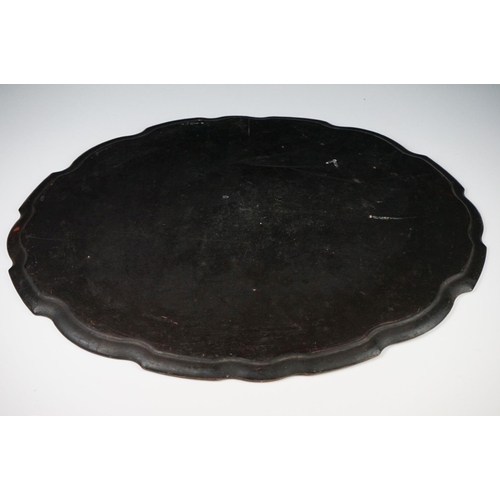86 - Black Lacquered Papier Mache Oval Tray with shaped edge decorated with flowers, 52cm long