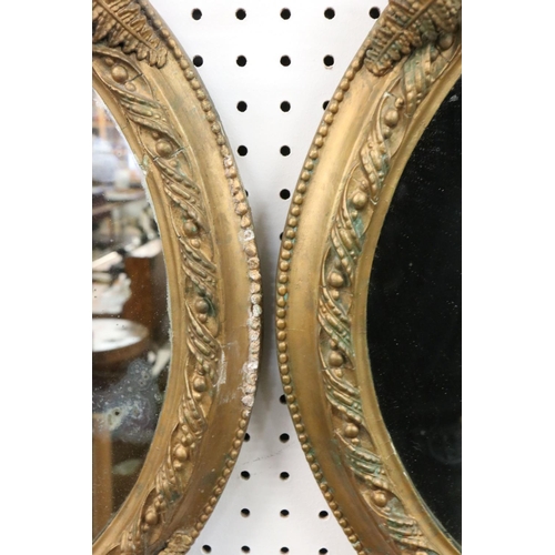 545 - Pair of 19th century Plaster Gilt Wall Mirrors, the oval plates within bead frames surmounted by fer... 