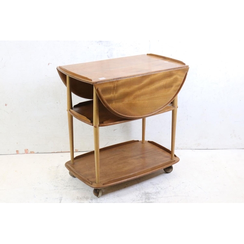 548 - Ercol Elm and Beech Trolley, model no. 505, with an oval drop-leaf top and raised on swivel castors,... 