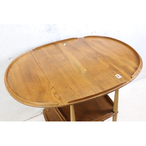 548 - Ercol Elm and Beech Trolley, model no. 505, with an oval drop-leaf top and raised on swivel castors,... 