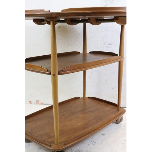 548 - Ercol Elm and Beech Trolley, model no. 505, with an oval drop-leaf top and raised on swivel castors,... 