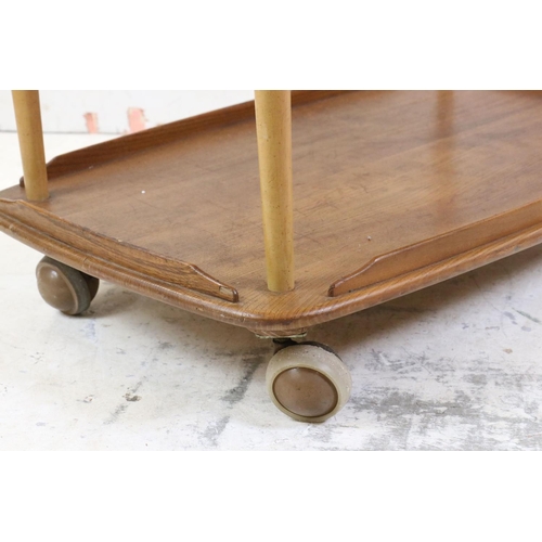 548 - Ercol Elm and Beech Trolley, model no. 505, with an oval drop-leaf top and raised on swivel castors,... 