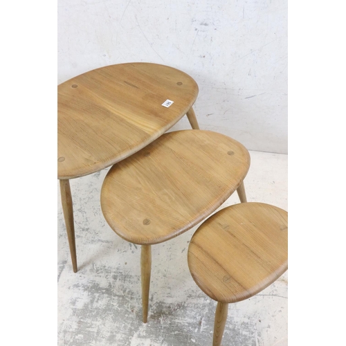 561 - Ercol Nest of Three Elm and Beech Pebble Tables, model no. 354 together with another small Ercol Peb... 