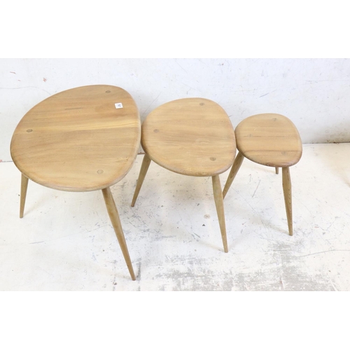 561 - Ercol Nest of Three Elm and Beech Pebble Tables, model no. 354 together with another small Ercol Peb... 