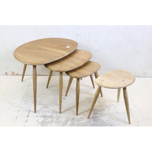 561 - Ercol Nest of Three Elm and Beech Pebble Tables, model no. 354 together with another small Ercol Peb... 