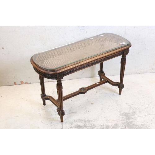 627 - Stained Wood Low Table, the cane inset shaped top with glass cover, carved frieze, raised on carved ... 