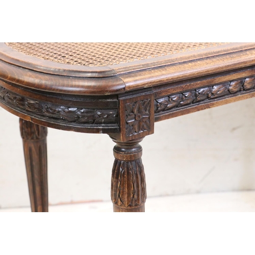 627 - Stained Wood Low Table, the cane inset shaped top with glass cover, carved frieze, raised on carved ... 