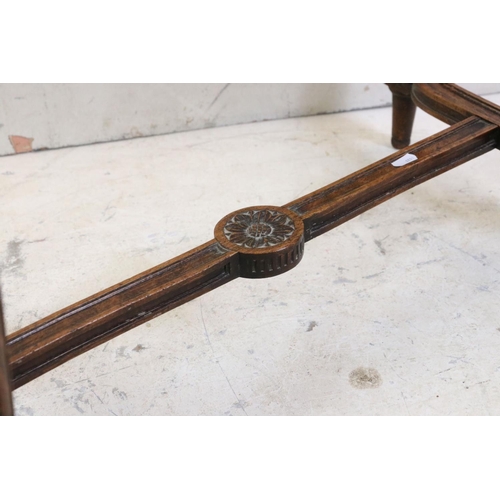 627 - Stained Wood Low Table, the cane inset shaped top with glass cover, carved frieze, raised on carved ... 