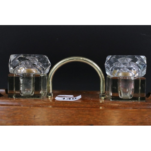 140 - Early 20th Century oak double inkwell desk stand with brass loop handle and square-shaped inkwells w... 