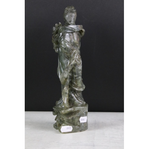 147 - Chinese carved jadeite figure of Guanyin, the figure in flowing robes holding a flower, 26cm high