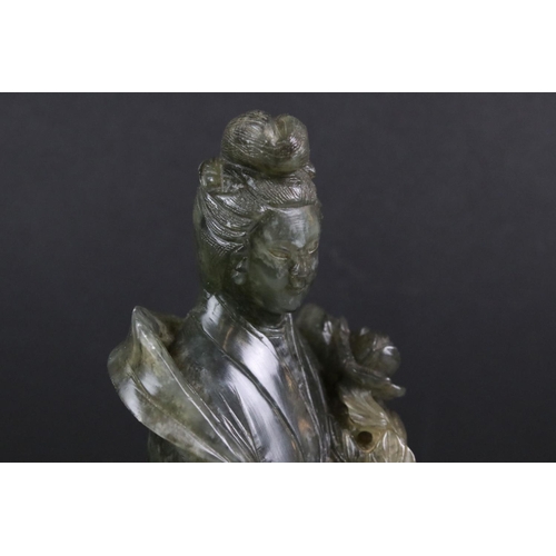 147 - Chinese carved jadeite figure of Guanyin, the figure in flowing robes holding a flower, 26cm high