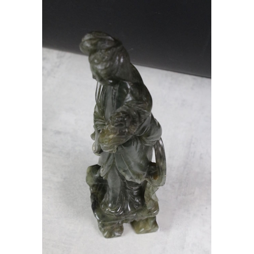 147 - Chinese carved jadeite figure of Guanyin, the figure in flowing robes holding a flower, 26cm high