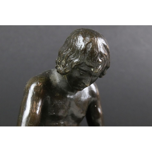 150 - Bronze figure of a nude male seated on a tree stump, checking the sole of his foot, raised on a circ... 