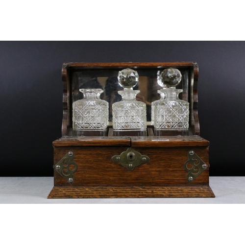 152 - Late 19th Century Brass Mounted Oak Three Bottle Tantalus, housing three cut glass decanters (2 with... 