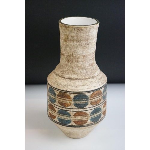 3 - Troika Urn Shaped Vase decorated with a double banding of blue and brown circles, on a rough texture... 