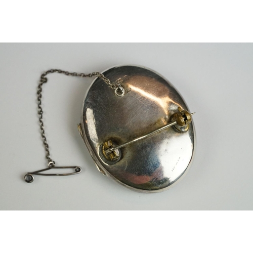 232 - A fully hallmarked sterling silver locket brooch with safety chain.