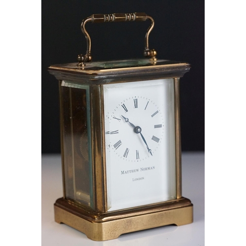 265 - A brass cased carriage clock with bevelled glass panels, Matthew Norman of London, complete with key... 