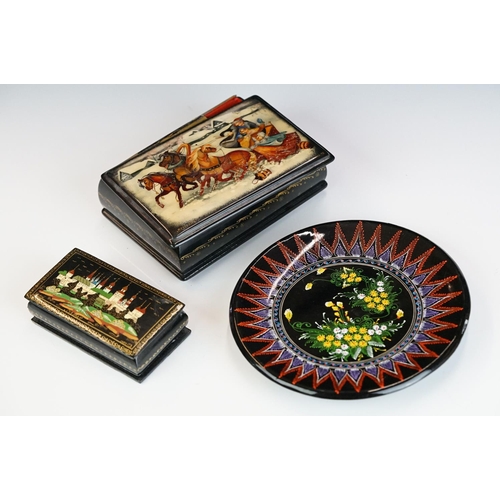 256 - Two Russian lacquerware trinket boxes, both signed to the lids, together with a similar dish.