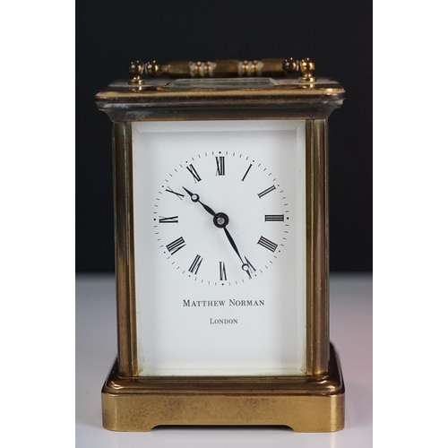 265 - A brass cased carriage clock with bevelled glass panels, Matthew Norman of London, complete with key... 