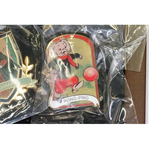 293 - A large collection of over fifty collectable Rupert The Bear pin badges contained within a glass top... 