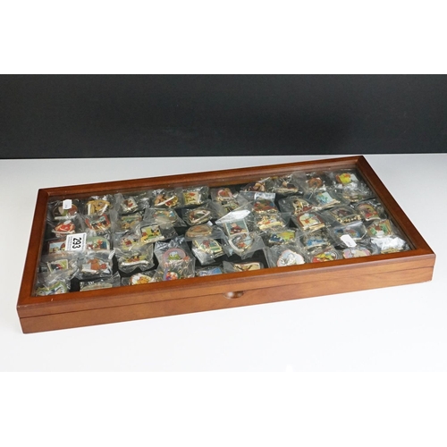 293 - A large collection of over fifty collectable Rupert The Bear pin badges contained within a glass top... 