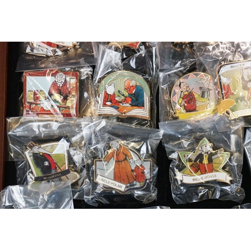 293 - A large collection of over fifty collectable Rupert The Bear pin badges contained within a glass top... 