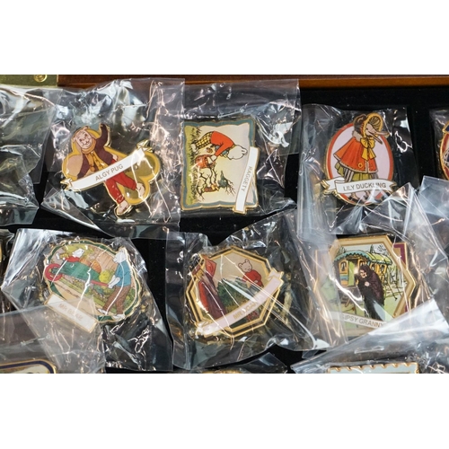 293 - A large collection of over fifty collectable Rupert The Bear pin badges contained within a glass top... 