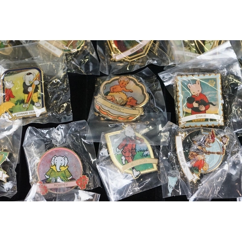 293 - A large collection of over fifty collectable Rupert The Bear pin badges contained within a glass top... 