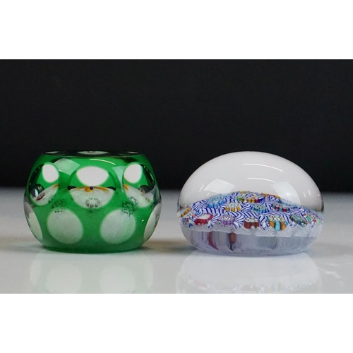 57 - Two Peter McDougal glass paperweights, to include a green overlay faceted example with central flowe... 