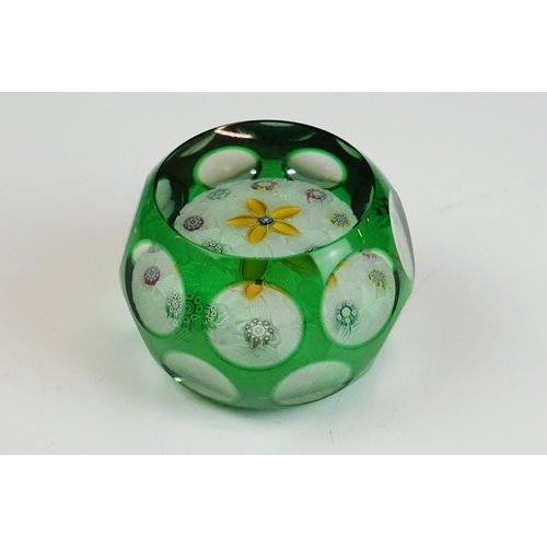 57 - Two Peter McDougal glass paperweights, to include a green overlay faceted example with central flowe... 