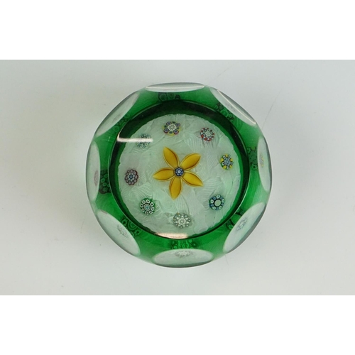 57 - Two Peter McDougal glass paperweights, to include a green overlay faceted example with central flowe... 