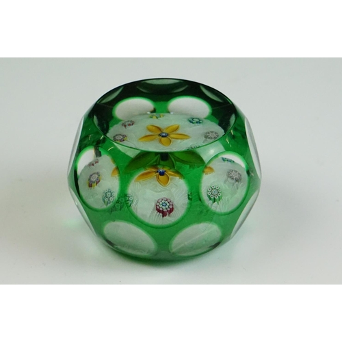 57 - Two Peter McDougal glass paperweights, to include a green overlay faceted example with central flowe... 