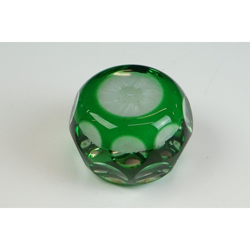 57 - Two Peter McDougal glass paperweights, to include a green overlay faceted example with central flowe... 