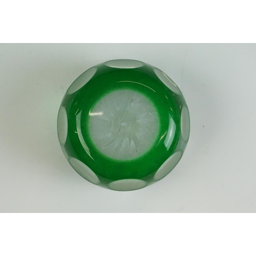 57 - Two Peter McDougal glass paperweights, to include a green overlay faceted example with central flowe... 