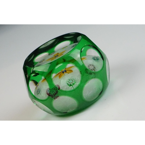 57 - Two Peter McDougal glass paperweights, to include a green overlay faceted example with central flowe... 