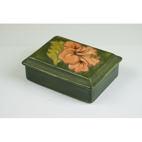 70 - Moorcroft Hibiscus pattern lidded trinket box on green ground, underglaze 'Moorcroft' mark to base, ... 