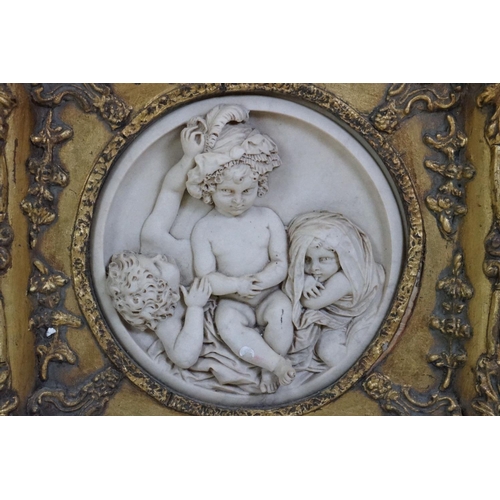 511 - Pair of Marble effect Plaster Plaques depicting children, 17cm diameter contained in ornate gilt fra... 