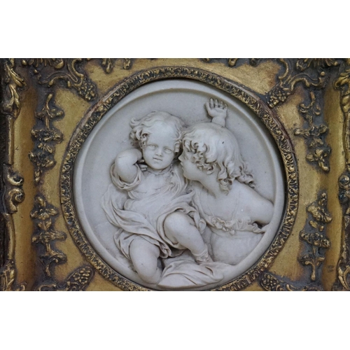 511 - Pair of Marble effect Plaster Plaques depicting children, 17cm diameter contained in ornate gilt fra... 