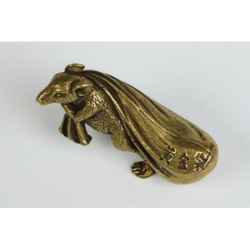 229 - A small brass ornamental Rat carrying bag of wealth figure.