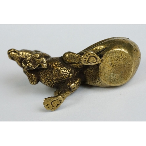 229 - A small brass ornamental Rat carrying bag of wealth figure.