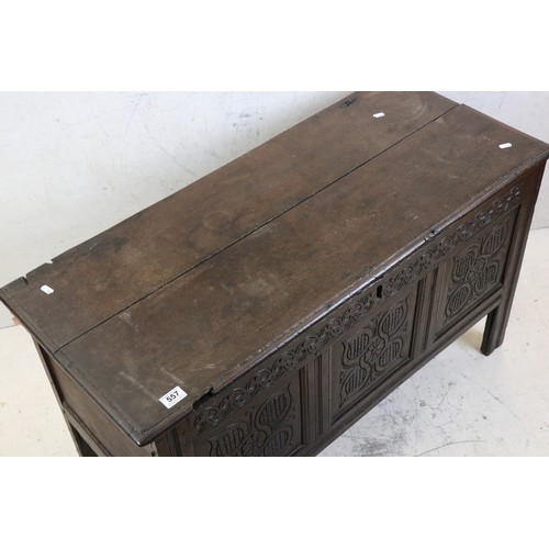 557 - 18th century Oak Coffer with two plank top and three carved panels to front, raised on stile legs, 1... 