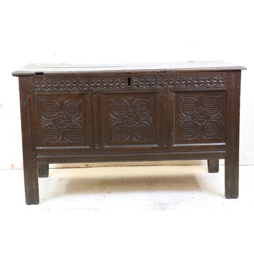 557 - 18th century Oak Coffer with two plank top and three carved panels to front, raised on stile legs, 1... 