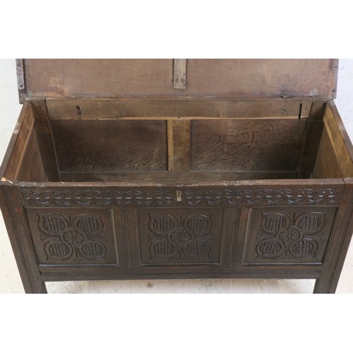 557 - 18th century Oak Coffer with two plank top and three carved panels to front, raised on stile legs, 1... 