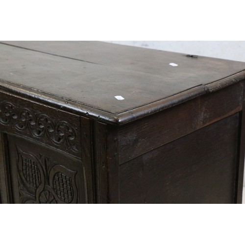 557 - 18th century Oak Coffer with two plank top and three carved panels to front, raised on stile legs, 1... 