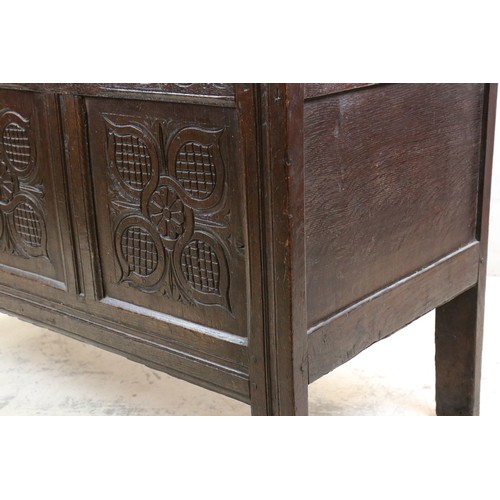 557 - 18th century Oak Coffer with two plank top and three carved panels to front, raised on stile legs, 1... 