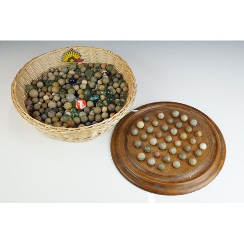 344 - A collection of mixed marbles together with a wooden solitaire board.