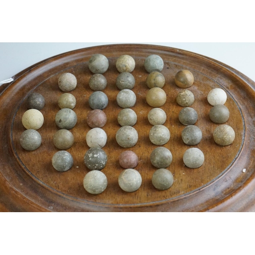 344 - A collection of mixed marbles together with a wooden solitaire board.