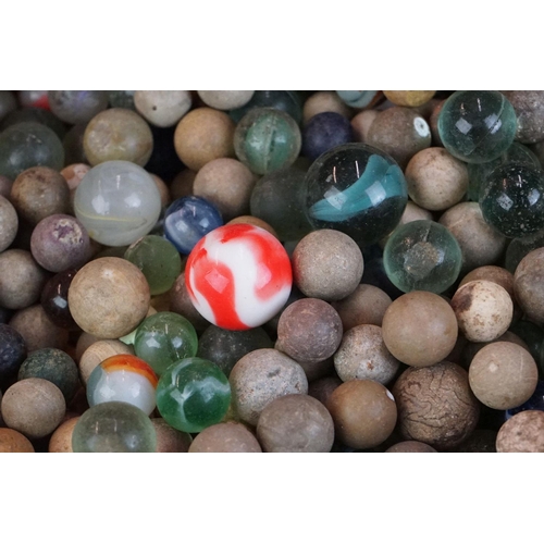 344 - A collection of mixed marbles together with a wooden solitaire board.