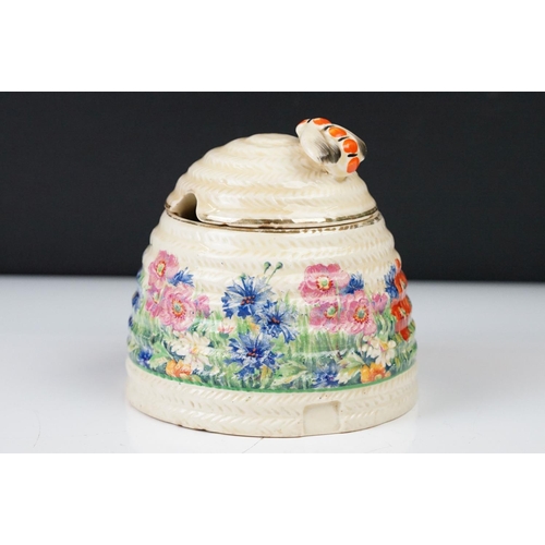 4 - Clarice Cliff Pottery Beehive Honey Pot in the Radiance pattern (damage to wing of bee), 11cm high