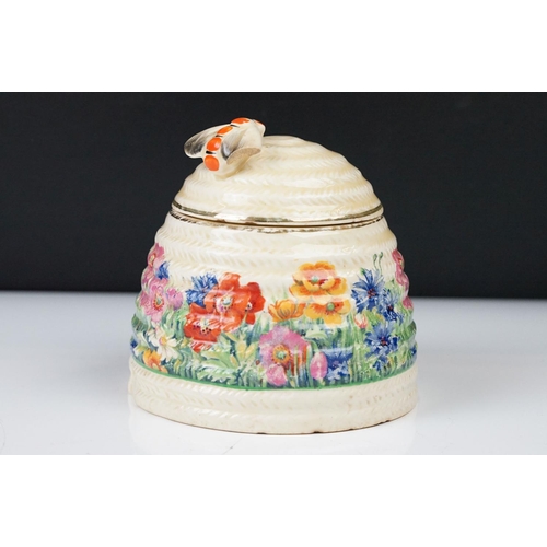 4 - Clarice Cliff Pottery Beehive Honey Pot in the Radiance pattern (damage to wing of bee), 11cm high